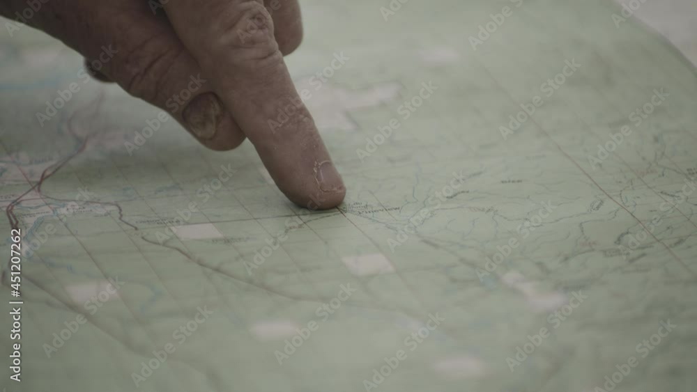 Wrinkled Finger Pointing On Geographical Map Of West Yellowstone In Montana Near Idaho. close up Wrinkled Finger Pointing On Geographical Map Of West Yellowstone In Montana Near Idaho. close up