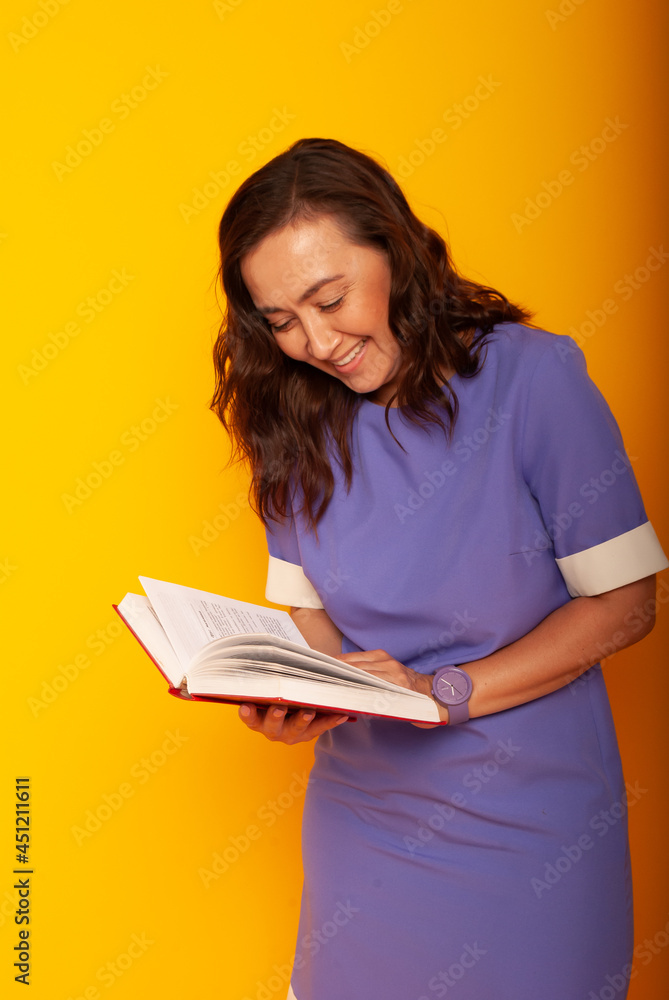 Teacher's Day, Knowledge Day. A woman in a dress on a yellow background with a book in her hands. online education. quarantine Teacher's Day, Knowledge Day. A woman in a dress on a yellow background with a book in her hands. online education. quarantine
