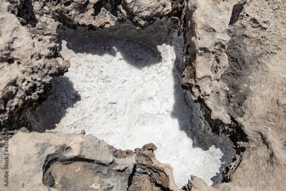 Fototapeta premium the sea coast in the form of bottom sediments flooded with seawater with the formation of salt patterns and sea lagoons in the form of textures and stone abstractions under water with shadows from the