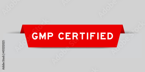 Red color inserted label with word GMP  (Abbreviation of good manufacturing practice) certified on gray background