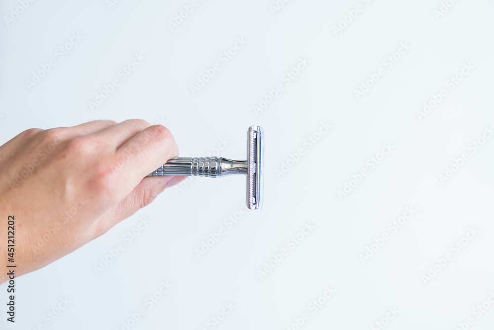 hand holding shaving metal and stainless razor isolated on white background. Zero waste and sustainable product for shaving