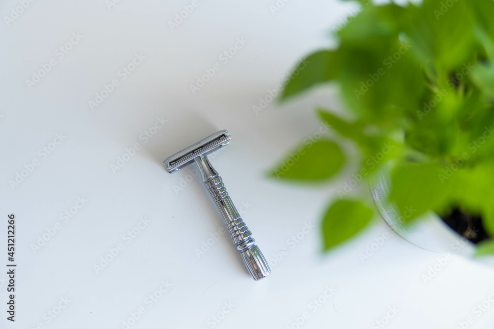 Vintage safety metal razor on a white background. Close-up. Isolated on white background. Reusable blade, zero waste product