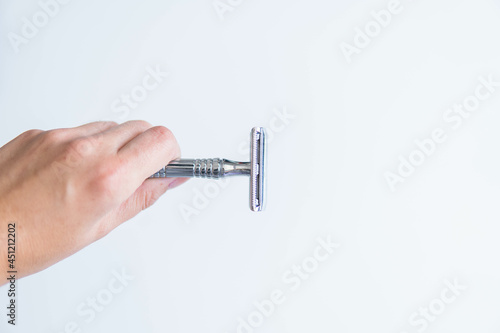 Obraz na płótnie hand holding shaving metal and stainless razor isolated on white background. Zero waste and sustainable product for shaving
w salonie