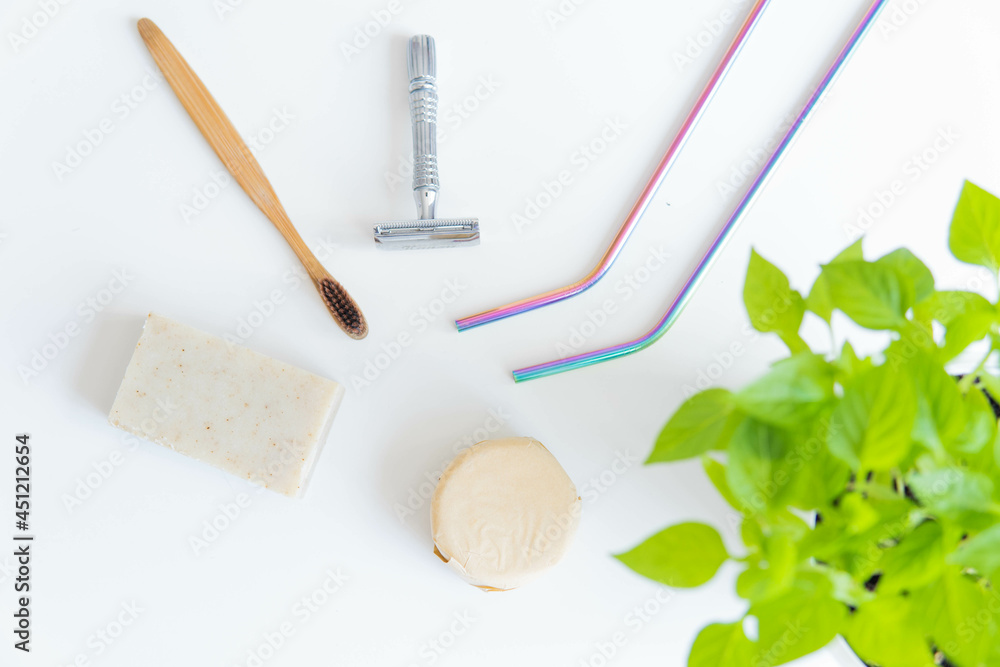 Zero waste product, close up caption. Bamboo toothbrush, solid shampoo, metal razor, metal straws and solid hand soap. Sustainable bathroom products on a white background.