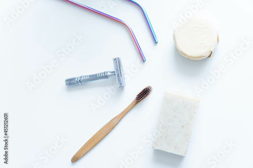 Obraz na płótnie Zero waste product, close up caption. Bamboo toothbrush, solid shampoo, metal razor, metal straws and solid hand soap. Sustainable bathroom products on a white background. w salonie