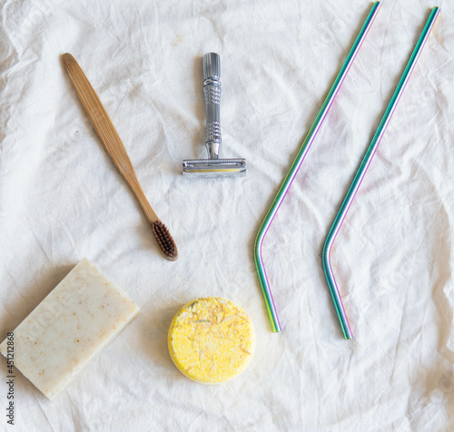 Obraz na płótnie Zero waste product, close up caption. Bamboo toothbrush, solid shampoo, metal razor, metal straws and solid hand soap. Sustainable bathroom products on a white background. w salonie