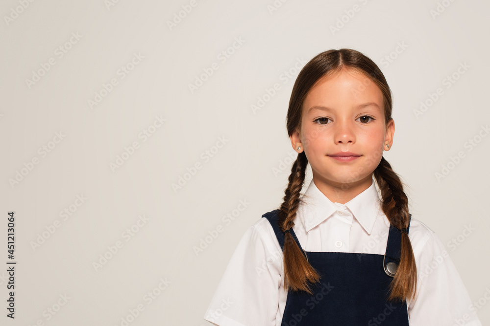 positive girl in school uniform looking at camera isolated on grey positive girl in school uniform looking at camera isolated on grey