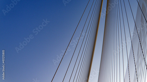 Cables of a suspension bridge over sky © Rohan
