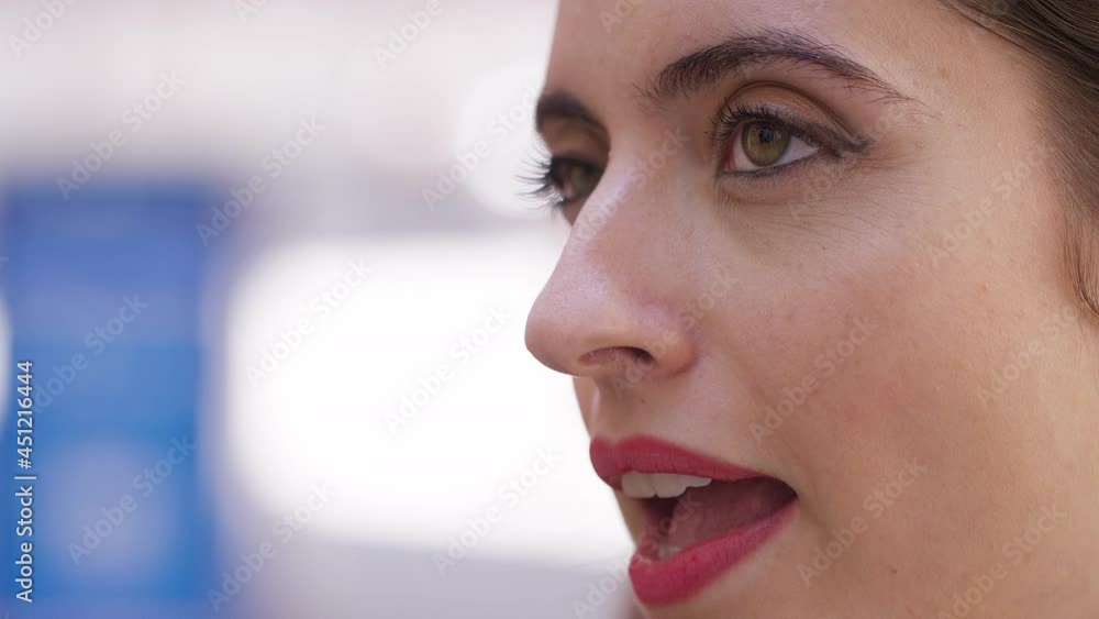 Static shot of young womans profile as she talks to someone off camera in the street Static shot of young womans profile as she talks to someone off camera in the street