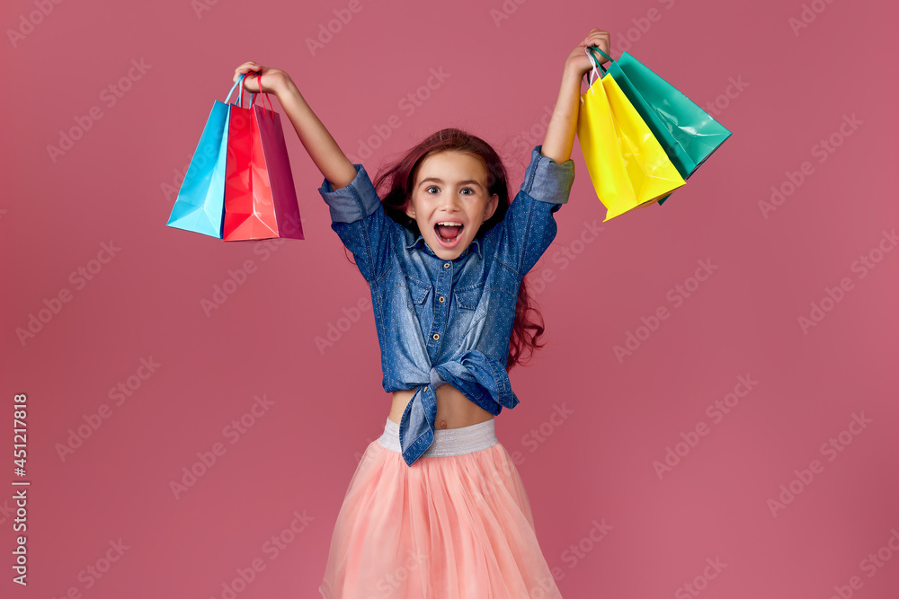 little caucasian child girl holds shopping bags