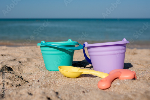 Shovels and buckets on coast sea background.  Beach toys for family vacation
