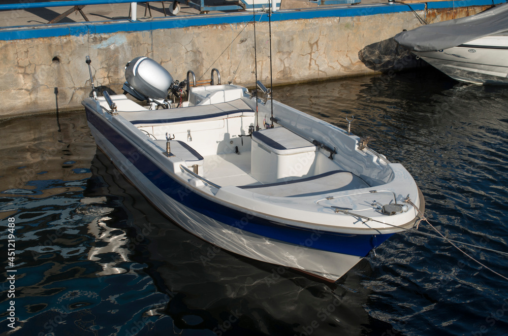 New small motor boat for fishing moored on pier Stock Photo