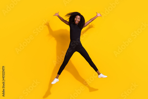 Full length body size photo of curly girl jumping high careless isolated on bright yellow color background