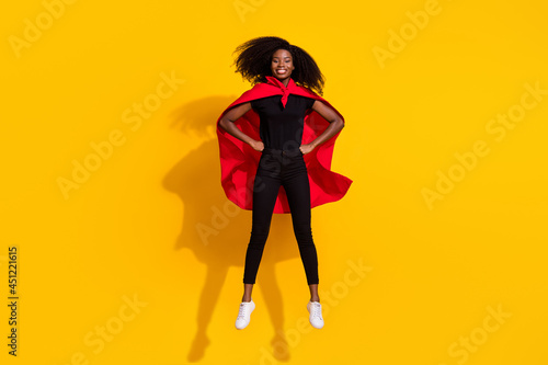 Full length body size photo curly girl jumping high wearing red cover super woman isolated on bright yellow color background