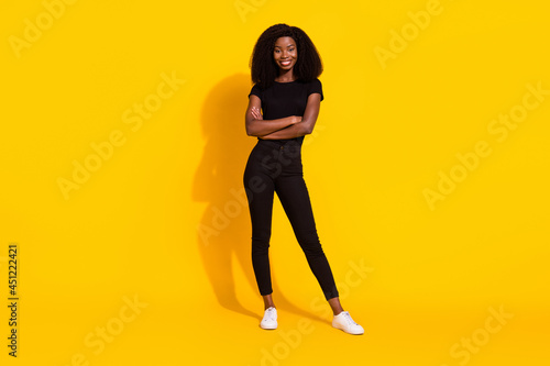 Full body photo of charming young happy afro american woman hold hands crossed isolated on yellow color background