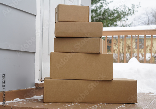 stacking delivered package boxes in front of the front door of house