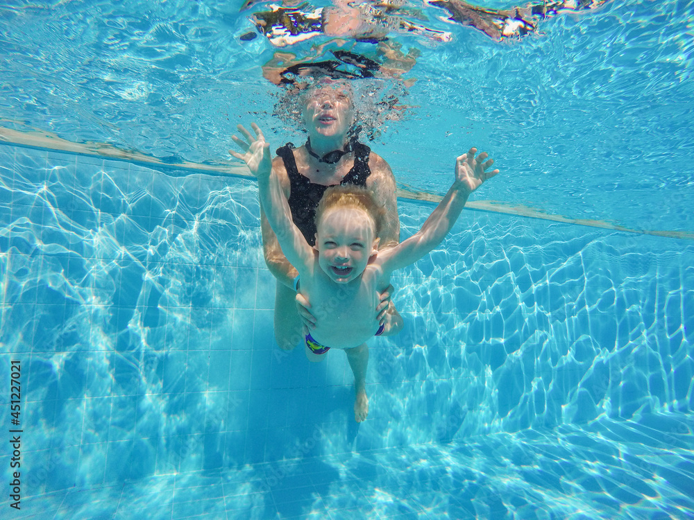 infant is underwater in the pool smiling