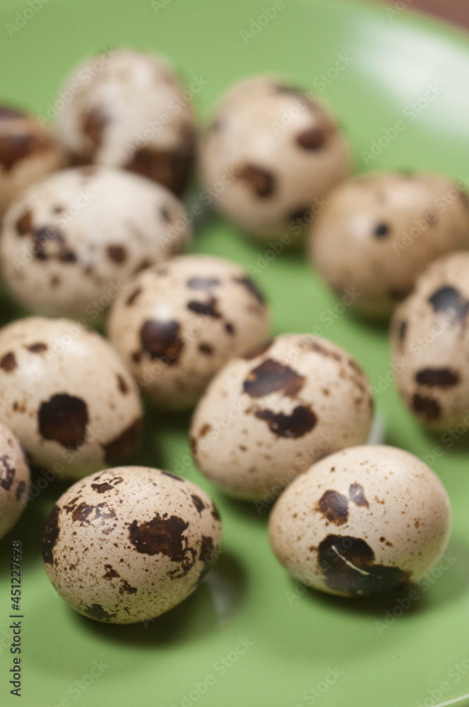 Fototapeta premium Quail eggs on a green ceramic plate