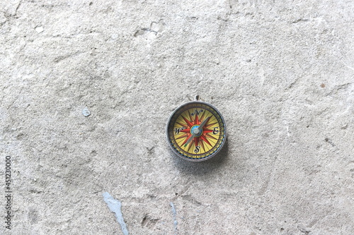 round compass on gray concrete background as symbol of tourism with compass, travel with compass and outdoor activities with compass