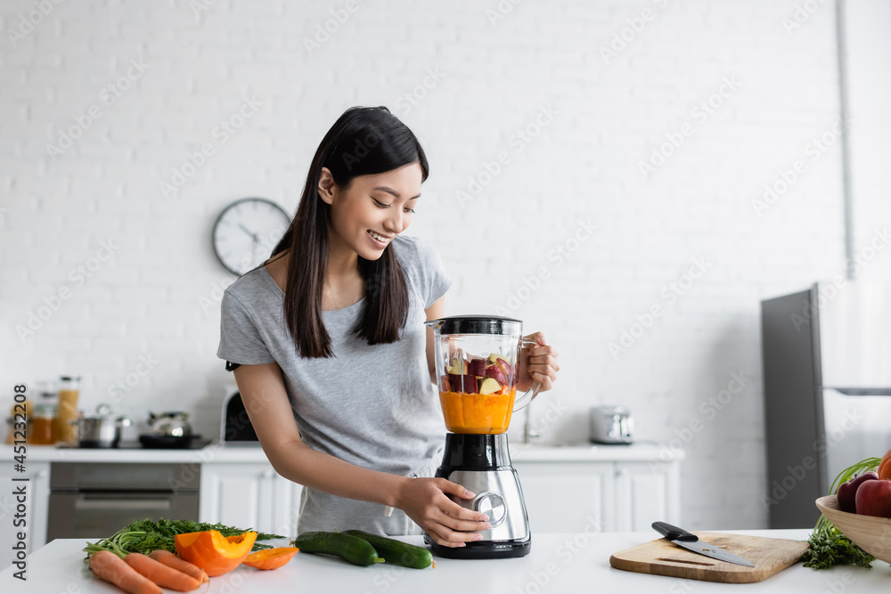 happy asian woman preparing fresh smoothie for breakfast in kitchen. happy asian woman preparing fresh smoothie for breakfast in kitchen.
