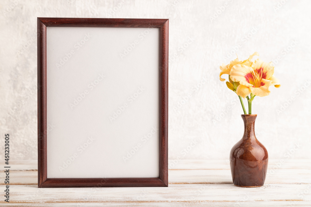 Wooden frame with orange day-lily flowers in ceramic vase on gray concrete background. side view, copy space. Wooden frame with orange day-lily flowers in ceramic vase on gray concrete background. side view, copy space.