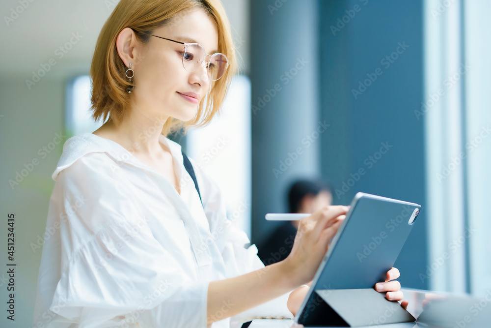 街なかでタブレットPCを操作する女性 街なかでタブレットPCを操作する女性