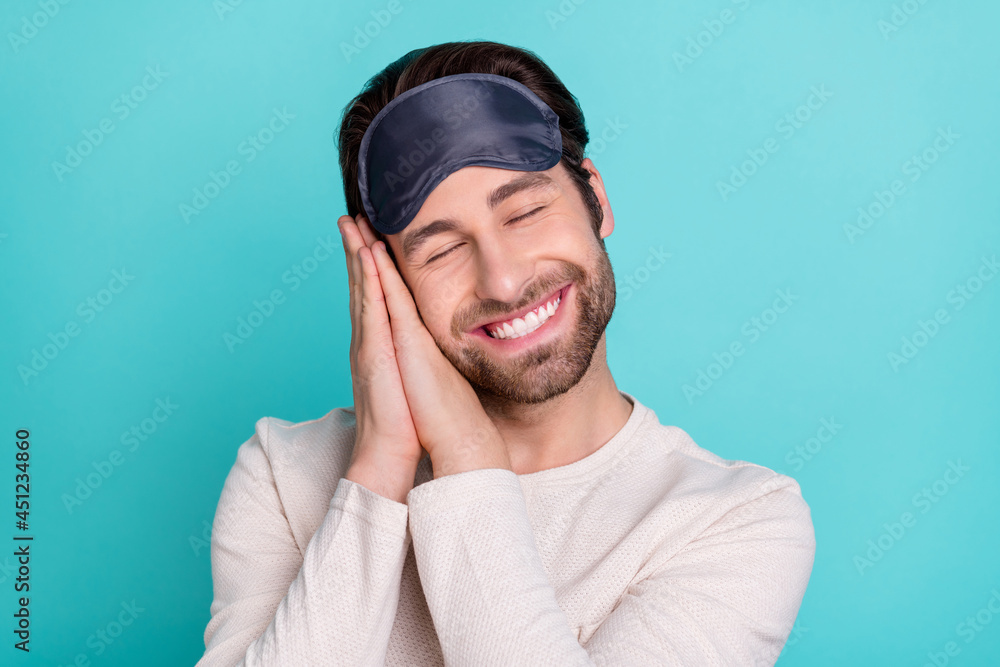 Photo of young cheerful man happy positive smile hands touch cheek sleep comfort cozy isolated over turquoise color background Photo of young cheerful man happy positive smile hands touch cheek sleep comfort cozy isolated over turquoise color background