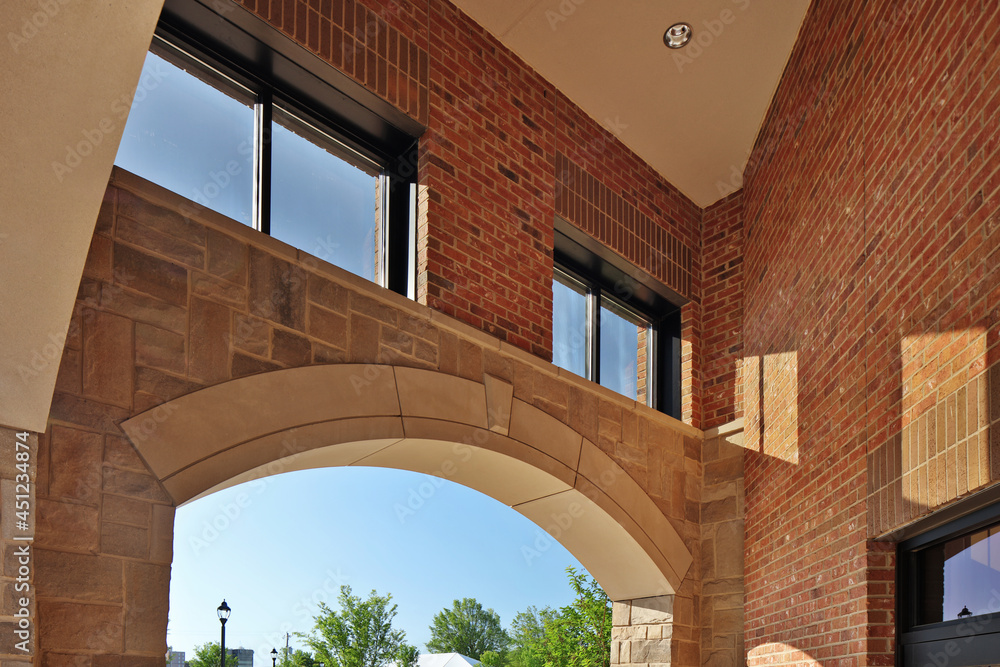 Stone arch in brick building with windows