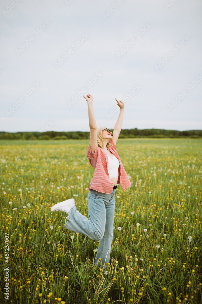 Cheerful woman showing horn gesture in summer field Cheerful woman showing horn gesture in summer field