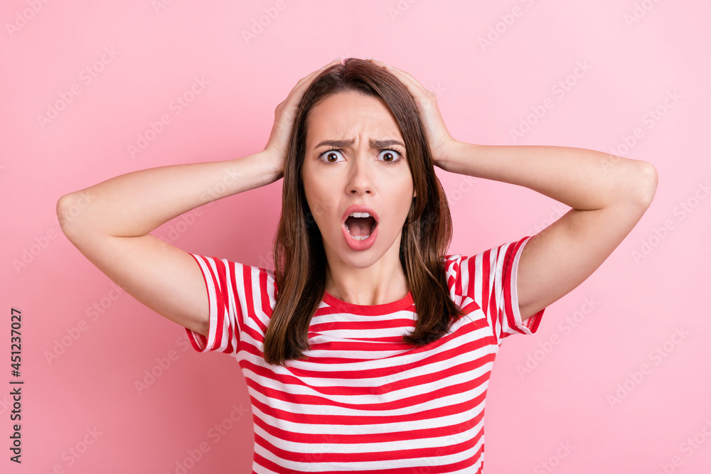 Photo of scared young brunette lady hands head wear red t-shirt isolated on pink color background Photo of scared young brunette lady hands head wear red t-shirt isolated on pink color background