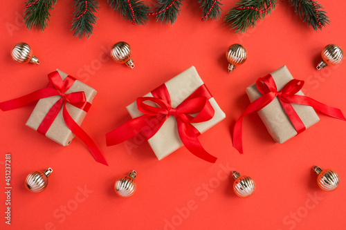 Top view of  Christmas gifts with tiew red bow on the red background. Close-up. photo