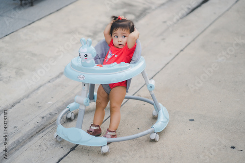 child happy time running in outdoor at road village to practice balance walk in development according to the age of the child on Baby car to help practice walking photo