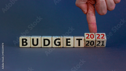 Planning 2022 budget new year symbol. Businessman turns wooden cubes and changes words 'Budget 2021' to 'Budget 2022'. Beautiful grey background, copy space. Business, 2022 budget new year concept.