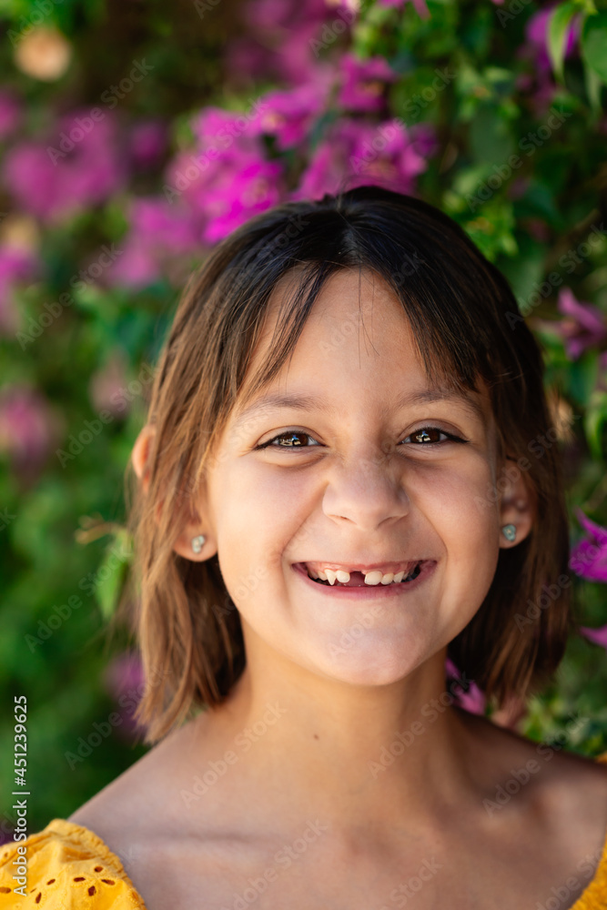 Smiling girl against blooming bush in garden Smiling girl against blooming bush in garden
