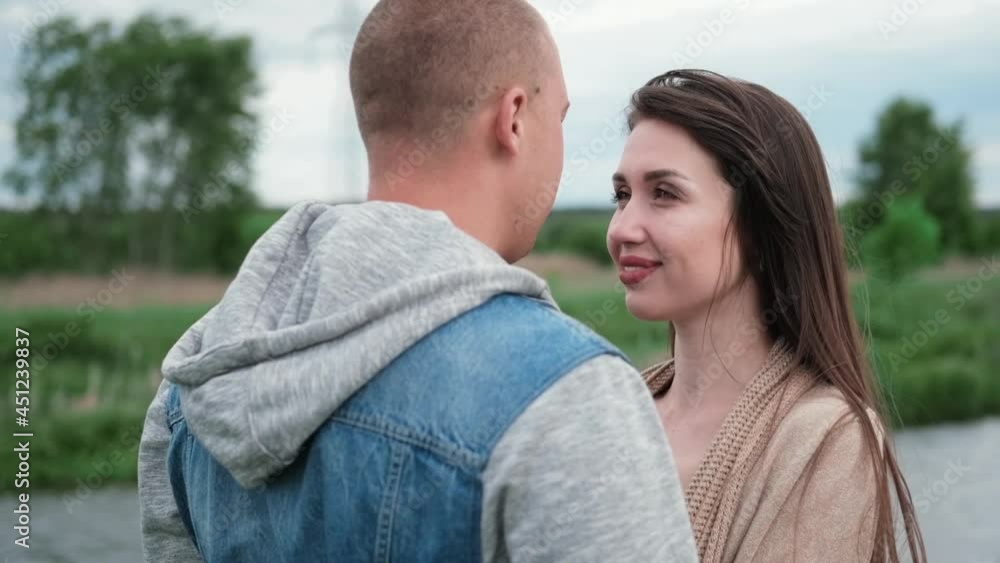 happy young couple outdoors near lake and green grass. bald man and brunette woman. husband and wife. millennials. successful marriage. true love. happy young couple outdoors near lake and green grass. bald man and brunette woman. husband and wife. millennials. successful marriage. true love.