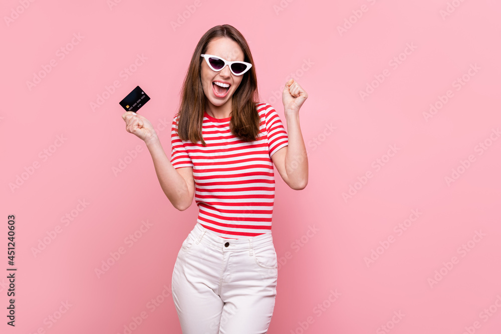 Photo of young excited girl happy positive smile rejoice hold credit card salary money isolated over pastel color background Photo of young excited girl happy positive smile rejoice hold credit card salary money isolated over pastel color background