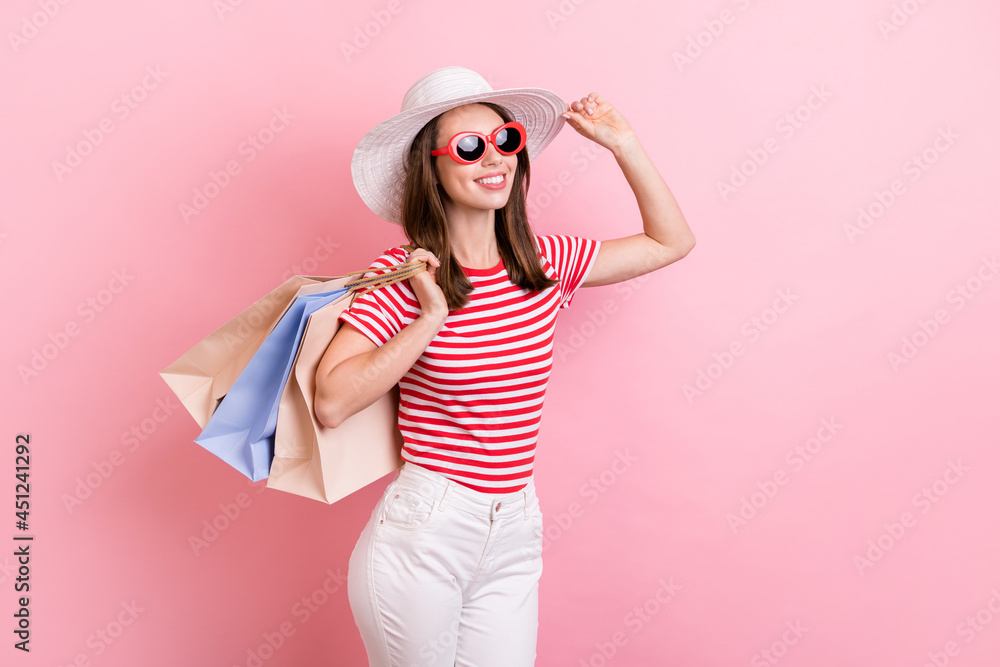 Profile side photo of young girl wear hat sunglass hold shopping bag shopaholic isolated over pastel color background Profile side photo of young girl wear hat sunglass hold shopping bag shopaholic isolated over pastel color background
