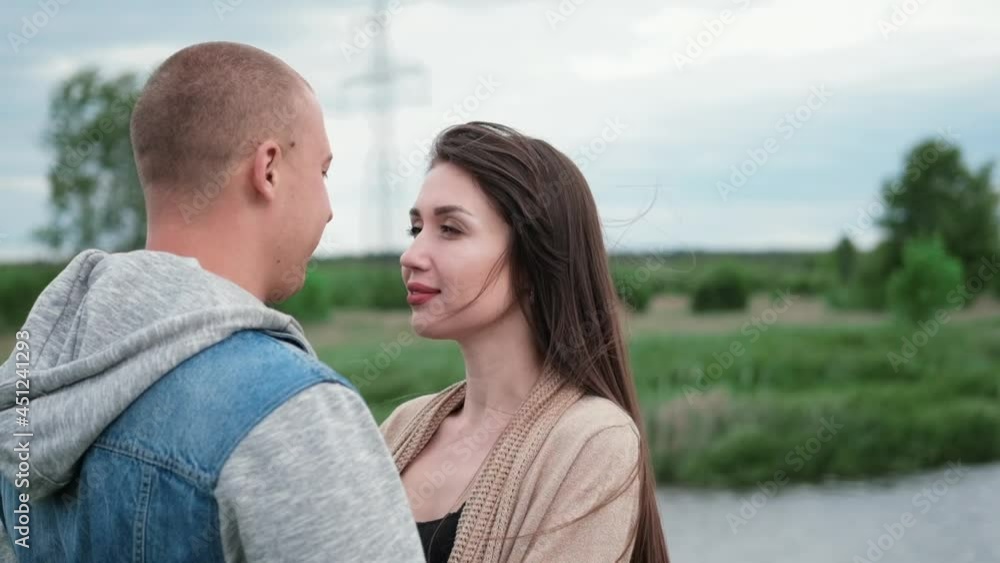 happy young couple outdoors near lake and green grass. bald man and brunette woman. husband and wife. millennials. successful marriage. true love. happy young couple outdoors near lake and green grass. bald man and brunette woman. husband and wife. millennials. successful marriage. true love.