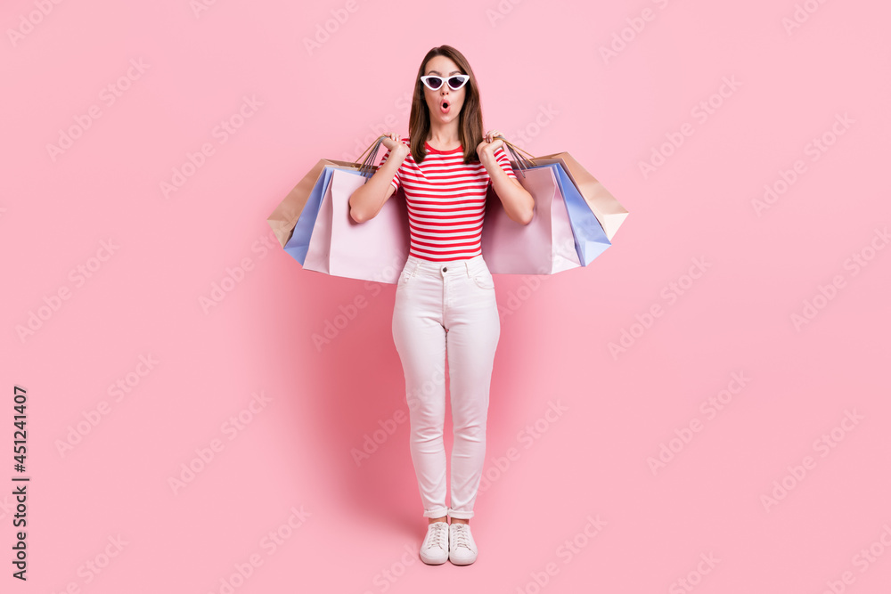 Full length photo of young attractive girl happy positive smile hold shopping bags isolated over pink color background