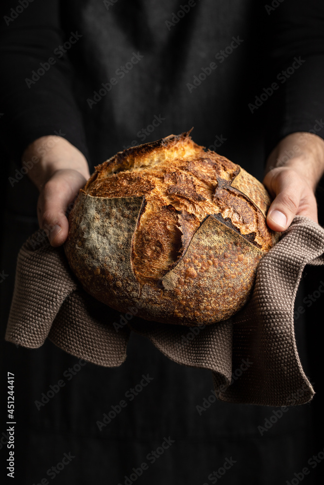 Crop cook holding bread loaf Crop cook holding bread loaf