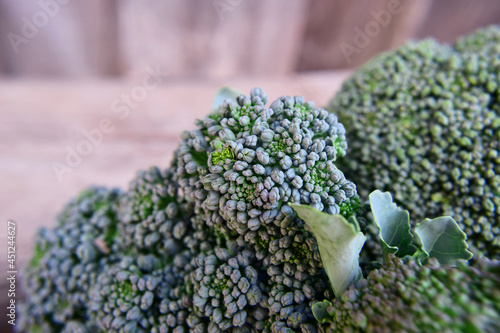 fresh harvest broccoli cabbage on wooden background selective focus, defocused background from left, close-up. broccoli cabbage growing concept.