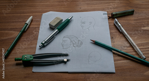 A beginner's drawing of a woman's face. On a wooden table.