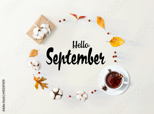 Hello September message with autumn leaves and tea