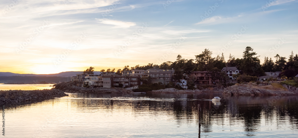 Obraz premium Scenic View of Residential Homes on the Coastline on the West Pacific Ocean Coast. Summer Sunset. MacAulay Point Park in Victoria, Vancouver Island, British Columbia, Canada.