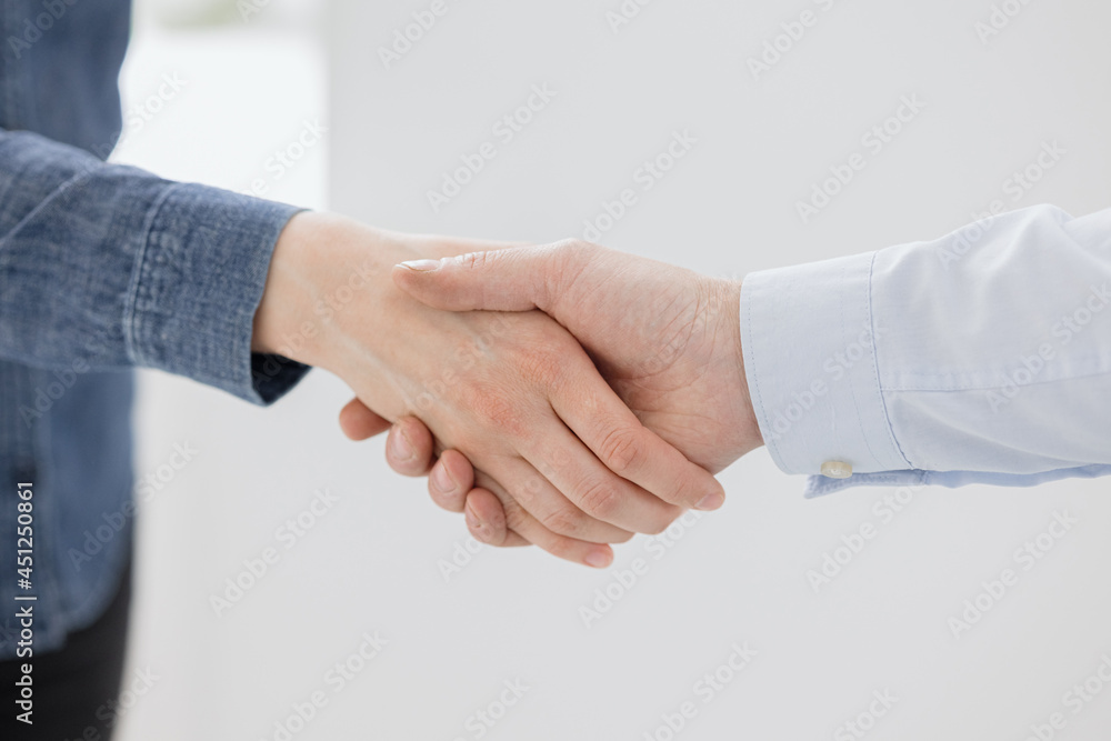 a handshake of two people, a man and a woman business partners greet a handshake after making a transaction, a friendly greeting or a gesture of agreement and success. partners have concluded a deal a handshake of two people, a man and a woman business partners greet a handshake after making a transaction, a friendly greeting or a gesture of agreement and success. partners have concluded a deal