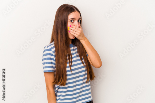Young caucasian woman isolated on white background covering mouth with hands looking worried.