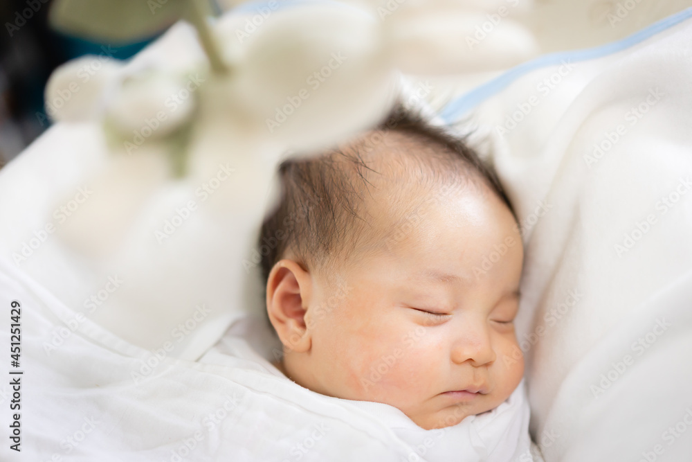 Child toy with rabbit hanging on baby cradle, blur sleeping baby background. Child toy with rabbit hanging on baby cradle, blur sleeping baby background.
