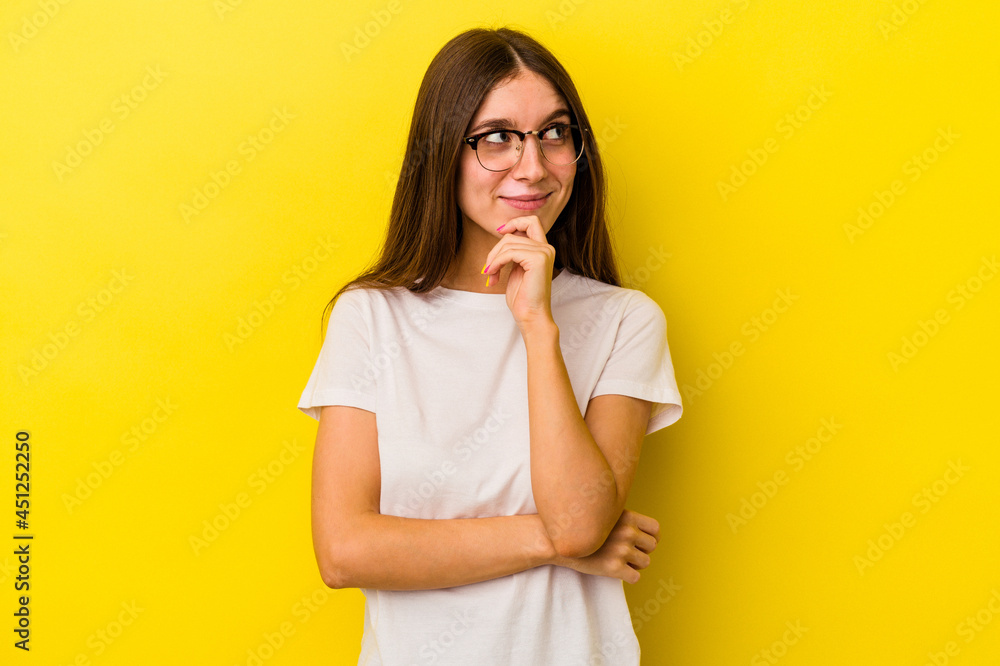 Young caucasian woman isolated on yellow background thinking and looking up, being reflective, contemplating, having a fantasy. Young caucasian woman isolated on yellow background thinking and looking up, being reflective, contemplating, having a fantasy.