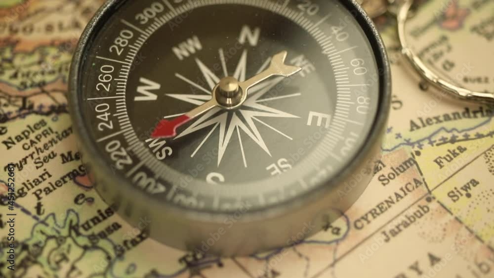Old compass on travel antique map background close-up, navigation and destination footage Old compass on travel antique map background close-up, navigation and destination footage