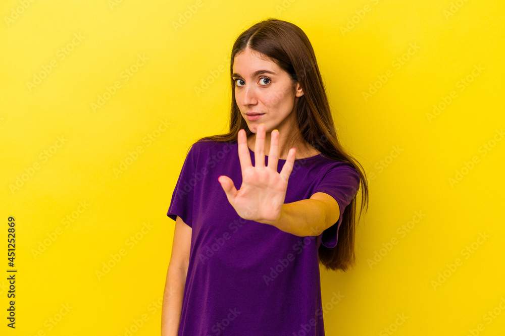 Young caucasian woman isolated on yellow background being shocked due to an imminent danger Young caucasian woman isolated on yellow background being shocked due to an imminent danger